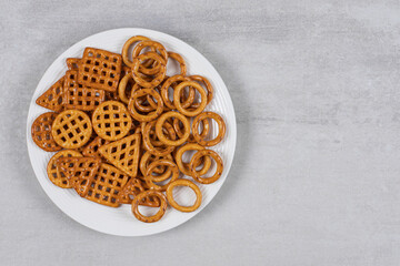 Various salty crackers on white plate