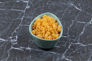 Close up photo of uncooked pasta in blue bowl