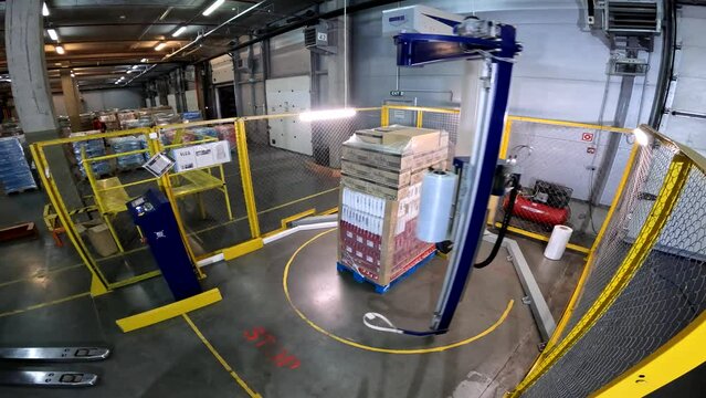 Packaging boxes in plastic film at the factory. A special machine wraps boxes in polyethylene film