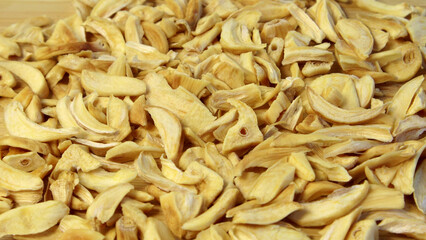 Dried garlic flakes on black plate close up flat lay photo on grey textured wooden background