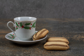 Cup of espresso with biscuits on marble background