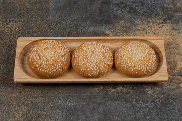 Biscuits with sesame seeds on wooden plate