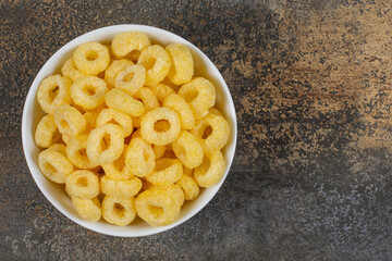 Tasty cereal rings in white bowl