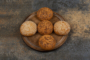 Cookies with sesame seeds and chocolate pieces on wooden board