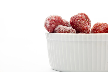 frozen strawberry in white ceramic bowl on white background with copy space 
