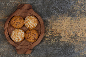 Biscuits with sesame seeds and chocolate pieces on wooden board