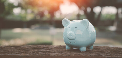 Saving money concep, charity, family finance plan concept, fundraising,blue piggy bank and icon family on table, investment, financial crisis concept.