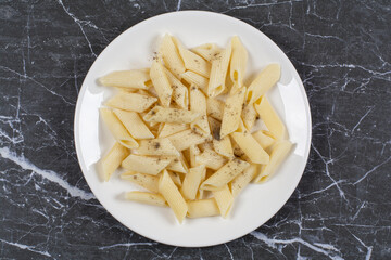 Top view of boiled penne pasta on plate