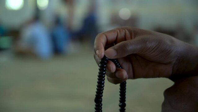 Detalle de la mano un musulm&aacute;n rezando con un Mishaba en una Mezquita Isl&aacute;mica. Madrid, Espa&ntilde;a, septiembre de 2022.
