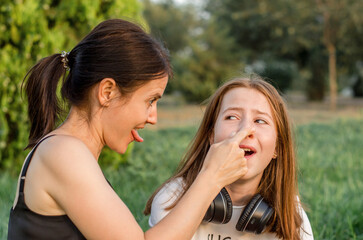 Mother and daughter are having fun. Portrait of a mother with her daughter in nature.