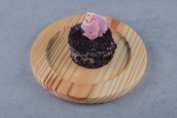 Close up photo of fresh mini cake on wooden plate
