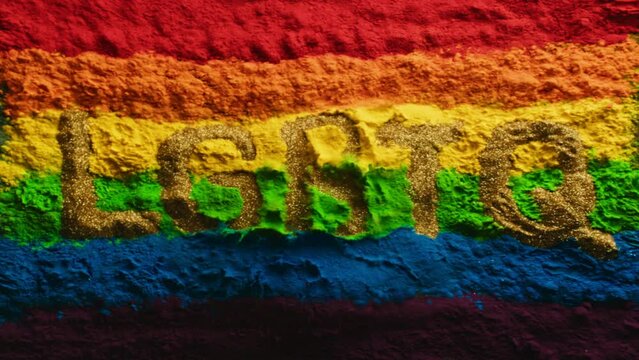 Super slow motion shot of color powder explosion rainbow flag with lgbtq text. Filmed on high speed cinema camera at 2000fps 4k prores 422.