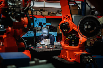 Naklejka na ściany i meble Industrial engineers are in charge of controlling the automated arms machine welding robots in companies that manufacture industrial goods.