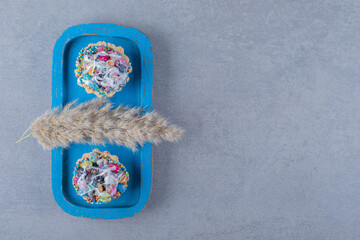 Fresh colorful homemade cookies on blue wooden board