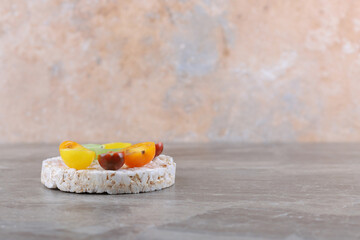 Different kinds of fruits on the puffed rice cakes, on the marble background