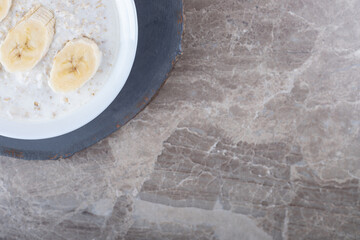 Sliced banana on a plate of rice, on the marble background
