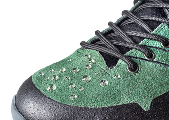 Raindrops on green suede boots for tracking close-up