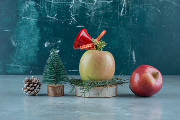 A fresh apple with red Christmas bell on a marble background