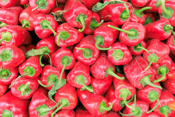 Bunch of red fresh organic peppers, paprika at the village market counter, Juicy all natural sweet red capia peppers stack at the farmers market, top view. 