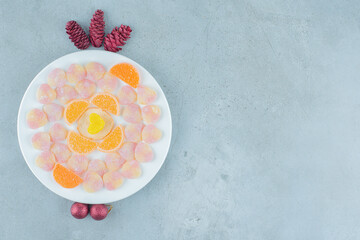 Obraz na płótnie Canvas A plate full of sugar heart shaped candies and pinecones