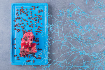 Top view of Turkish delight rahat lokum and dry raisins on blue wooden board