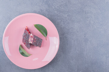 Top view of Turkish delight rahat lokum on pink plate over grey background