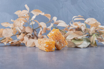 Yellow traditional turkish delight (rahat lokum) with peanuts on grey background with decorative...