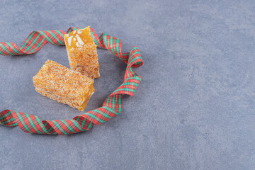 Yellow traditional turkish delight (rahat lokum) with peanuts on grey background