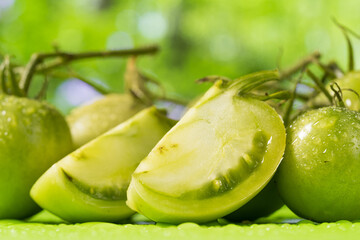 Fresh green tomatoes on a solid background