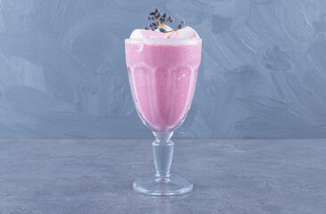 Close up photo of Freshly made pink milk shake on grey background