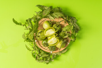 Fresh green tomatoes on a solid background
