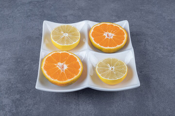 Close up photo of Fresh orange and lemon slices on white plate