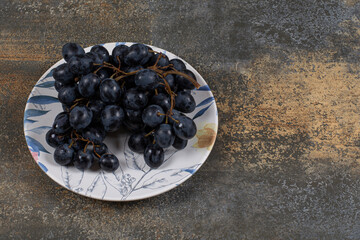 Fresh black grapes in colorful plate