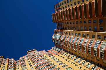 A modern high-rise residential building in the city against blue sky. 