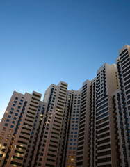 Obraz premium A modern high-rise residential building in the city against blue sky. 