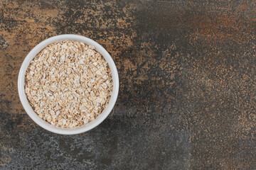 Dry oat flakes in white bowl