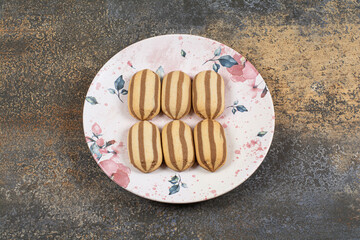 Tasty chocolate striped biscuits on colorful plate