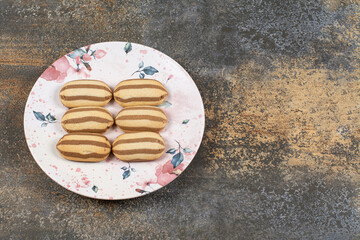 Tasty chocolate striped biscuits on colorful plate
