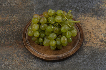 Ripe green grapes in wooden board