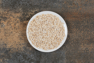 Tasty oat flakes on white plate