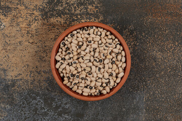 Pile of raw white beans in ceramic bowl
