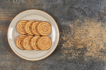 Tasty biscuits with sesame seeds on ceramic plate