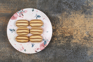 Tasty chocolate striped biscuits on colorful plate