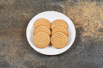 Pile of tasty round biscuits on white plate