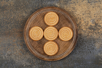 Pile of tasty biscuits on wooden plate