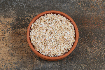 Dry oat flakes in ceramic bowl