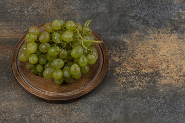 Ripe green grapes in wooden board