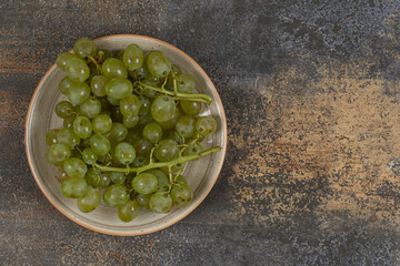 Fresh green grapes on ceramic plate