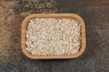 Dry oat flakes on wooden plate