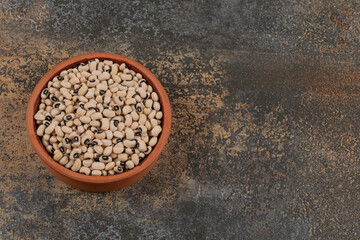 Pile of raw white beans in ceramic bowl